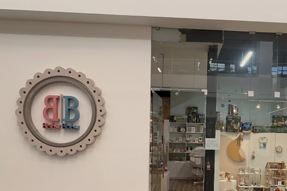 BabyBaby storefront with its scalloped BB logo on the wall and a glass front showing wooden toys